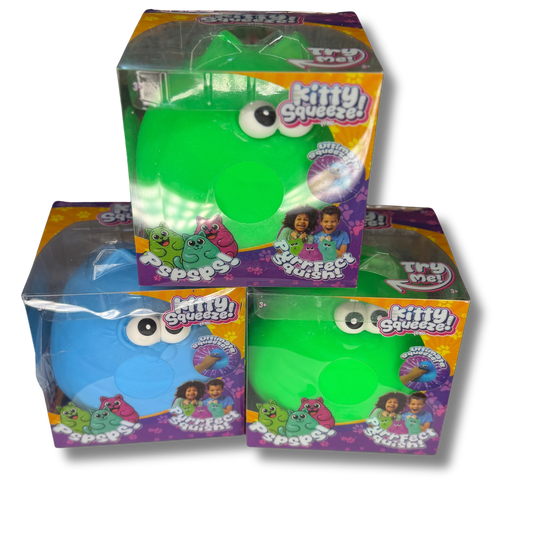 Three boxed 'Kitty Squeezes!' surface tension toys stacked in a pyramid on a white background. The top box contains a green toy, and the two lower boxes contain blue and green versions respectively, all in clear plastic packaging with colorful orange, purple, and yellow labels.