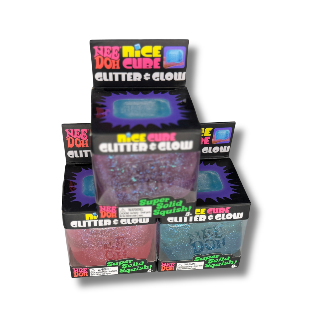 A retail display box of Nee Doh Glitter Glow Super Solid Squishy, showing two different colored cubes: one pink glitter and one blue glitter, inside a black display stand with colorful branding.