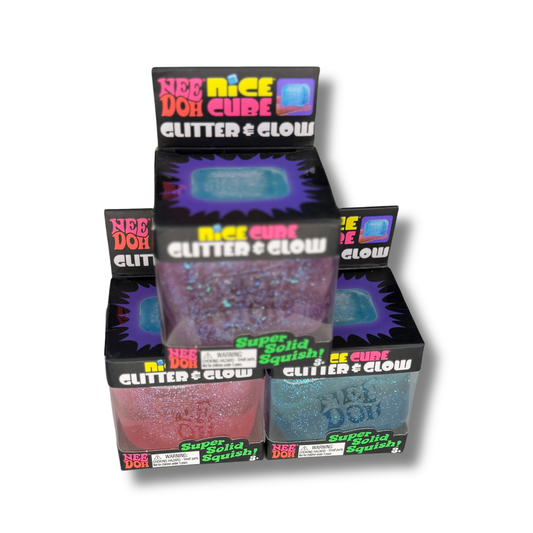 A retail display box of Nee Doh Glitter Glow Super Solid Squishy, showing two different colored cubes: one pink glitter and one blue glitter, inside a black display stand with colorful branding.
