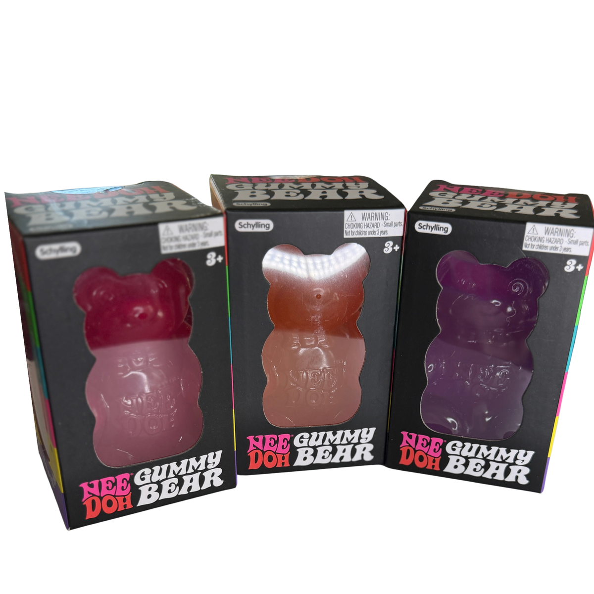 Three boxed gummy bear candies on a plain white background. The boxes are black with colorful text and show the gummies through clear windows: a pink bear, a peach-orange bear, and a purple bear.