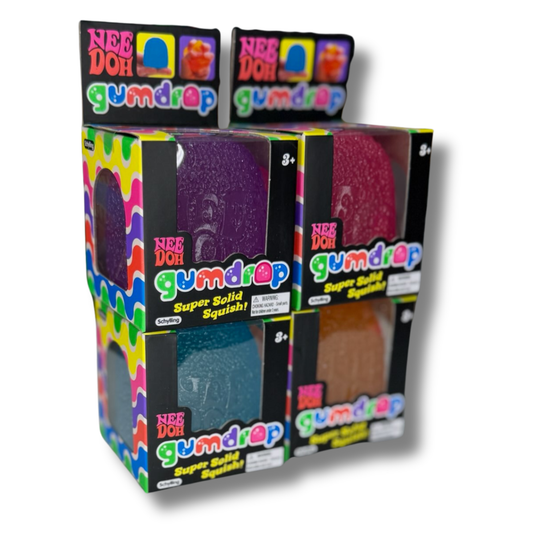 A retail display box of Nee Doh Gumdrop Super Solid Squishies, showing four different colored gummy eggs (purple, pink, blue, and brown) in clear plastic windows with colorful branding.