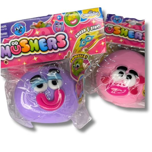Two packaged smushers toy figures from Chosha's, one purple and one pink, in clear plastic wrapping with colorful branded cardboard headers.