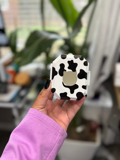 Back of black and white cow print case with a cat-shaped opening